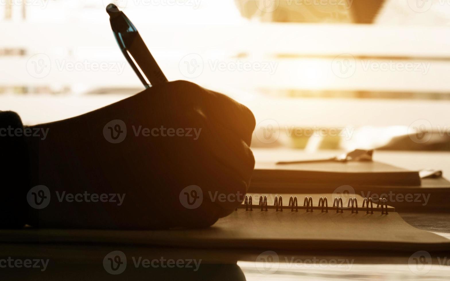 cerrar notas de escritura a mano en el notbook en el escritorio foto