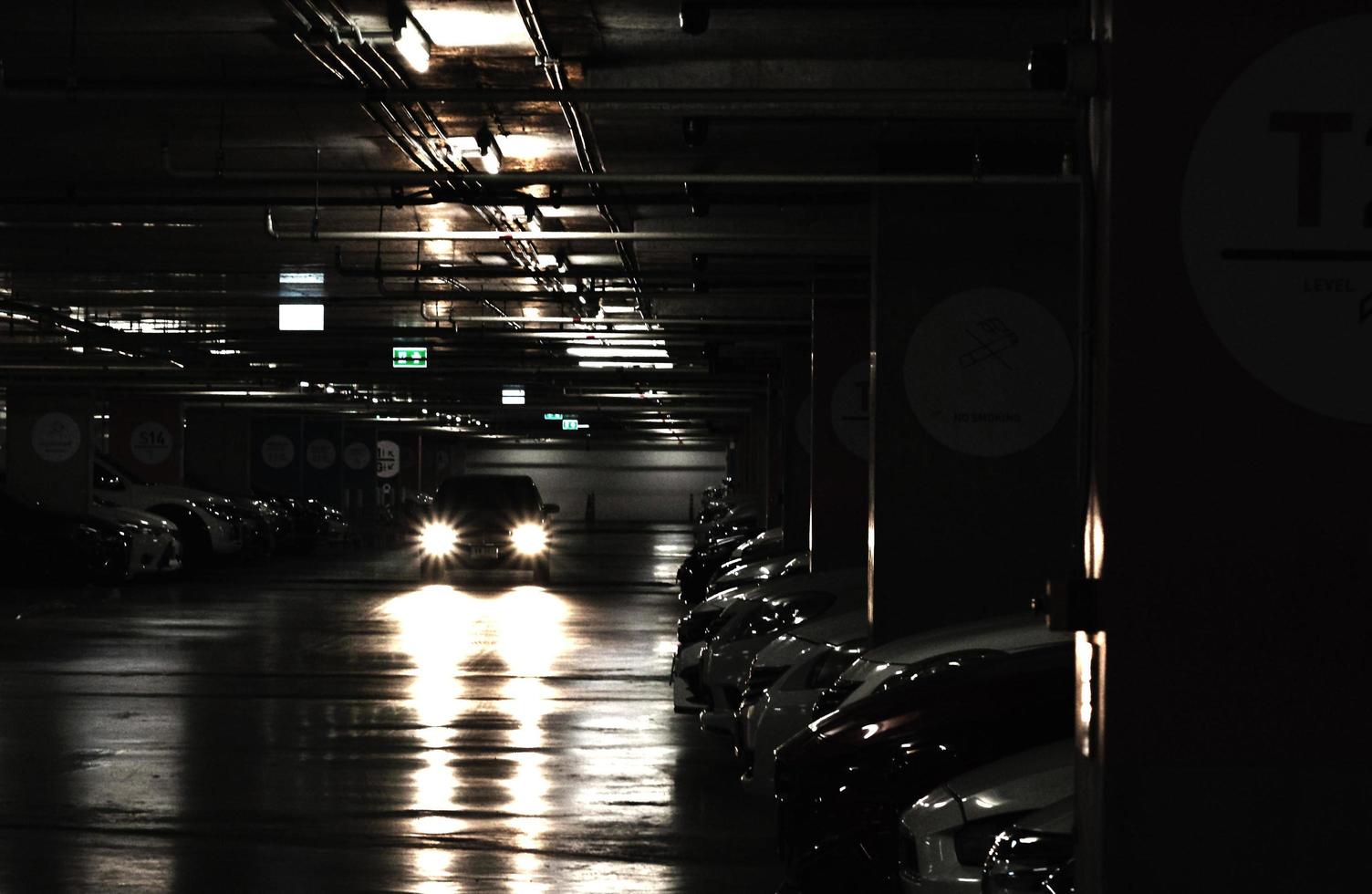 cars parking in parking lot in dark photo