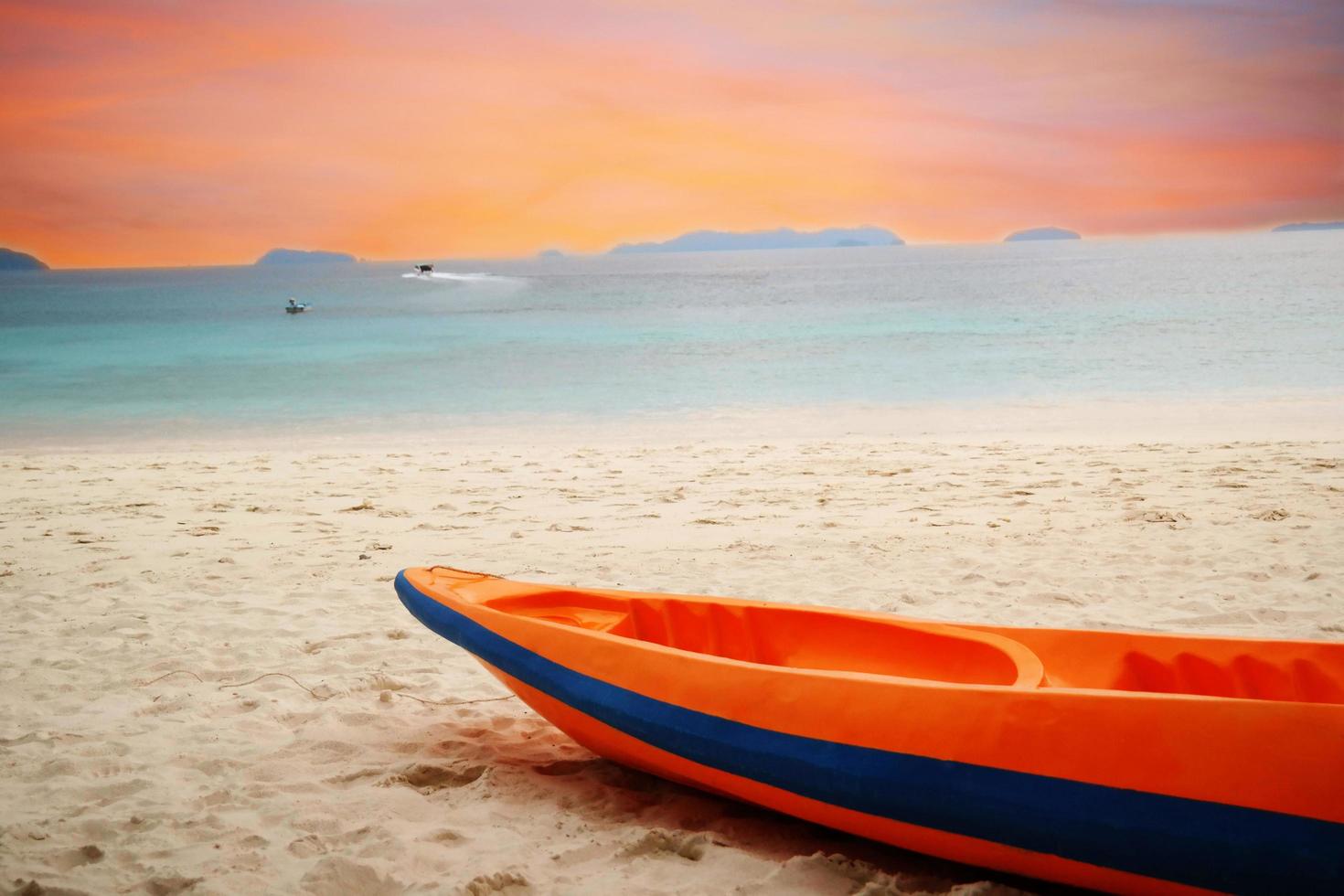 orange kayak boat on beach photo