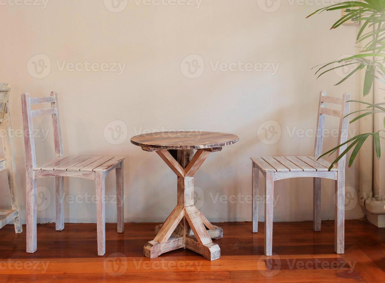 retro wooden table set with chairs over white wall photo