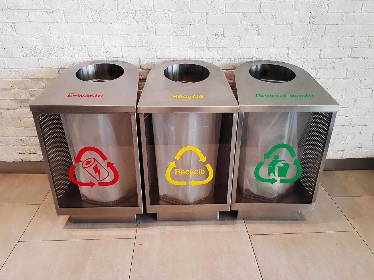 three modern stainless trashcans on floor photo