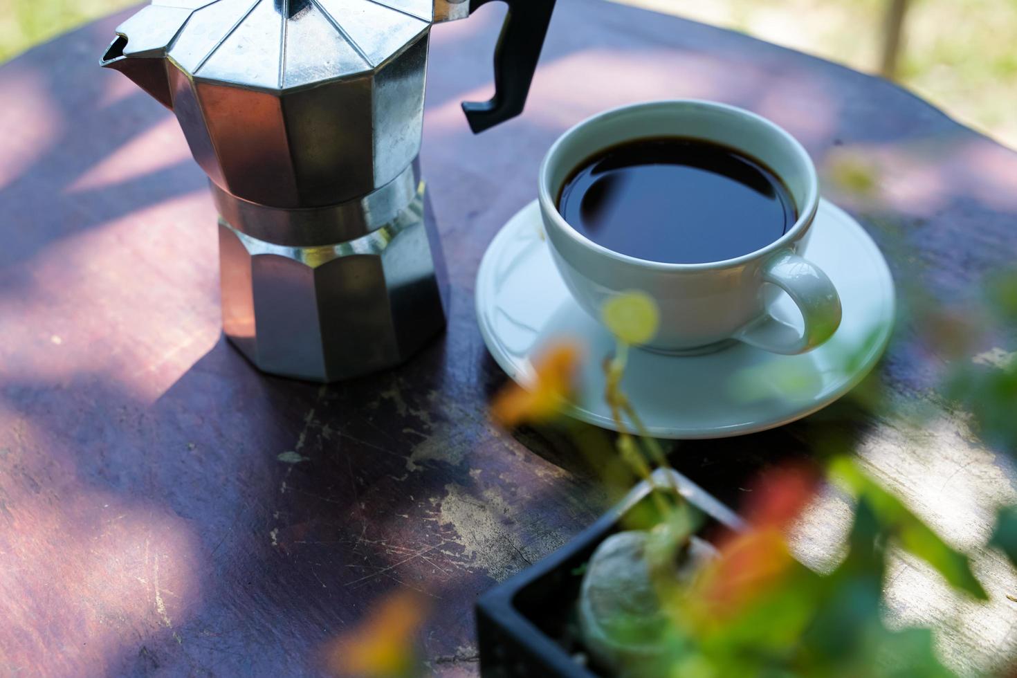 café negro caliente en una taza blanca, el café es una bebida popular en todo el mundo. foto