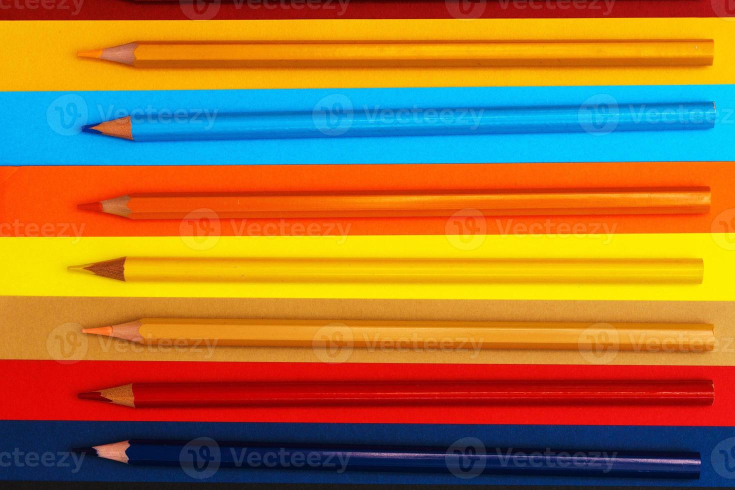 Colored pencils on a multi-colored background. Many pencils of different colors. photo
