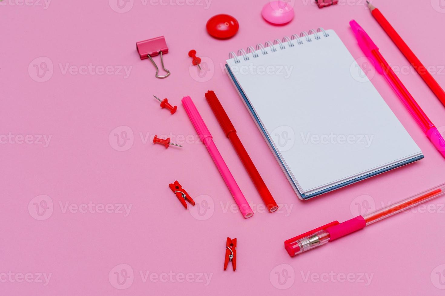 papelería en tonos rosa pastel. sobre un fondo rosa, plano. marcadores foto