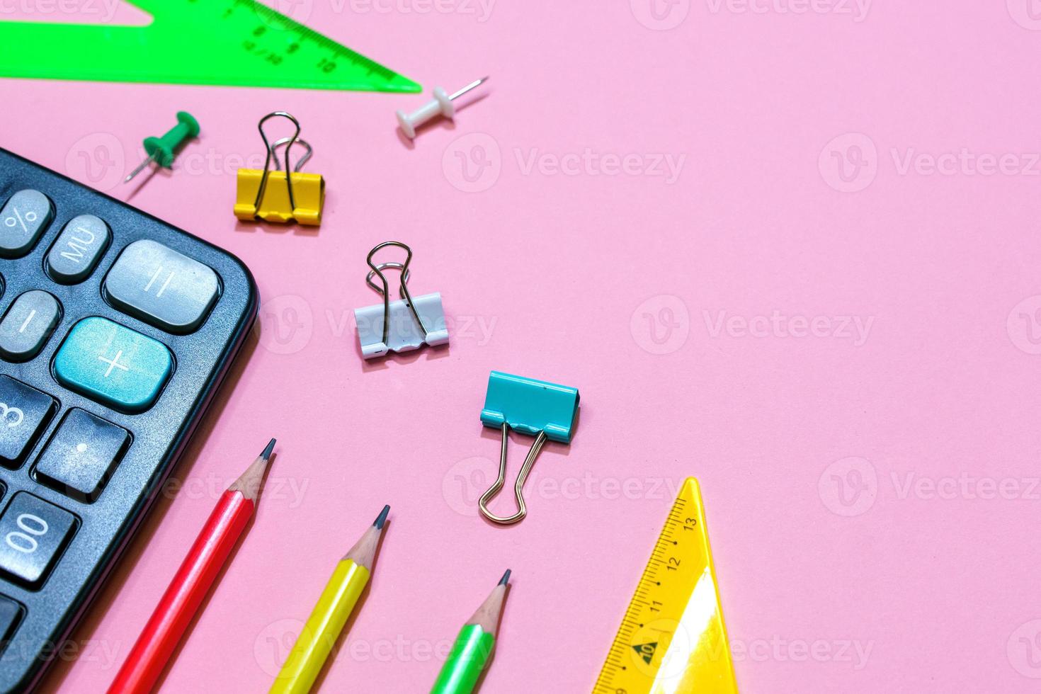 School supplies on a pink background. View from above. Copy space. photo