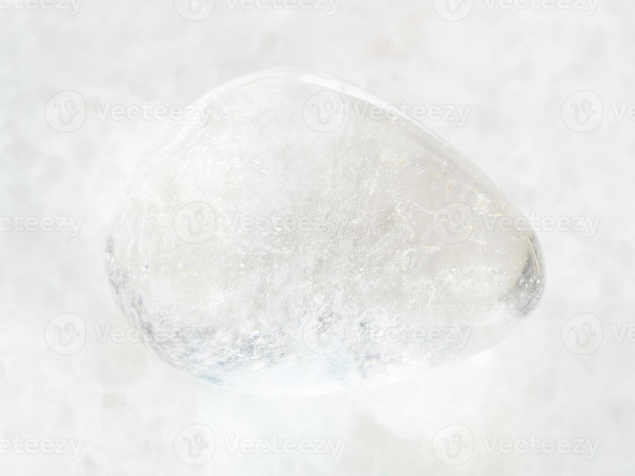 piedra preciosa de cristal de roca caída sobre mármol blanco foto