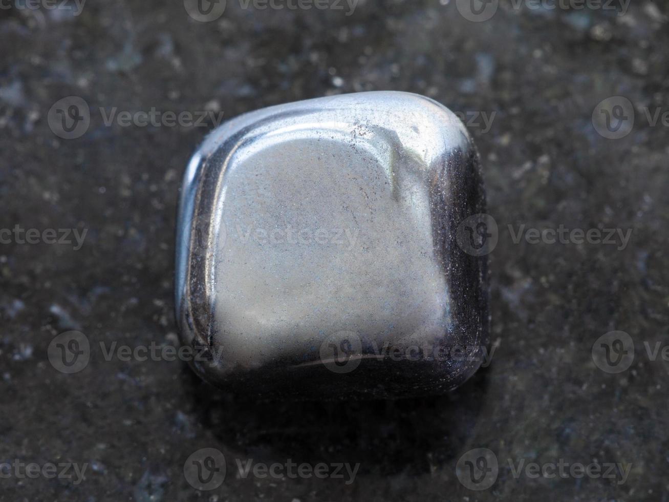 polished hematite stone on dark background photo