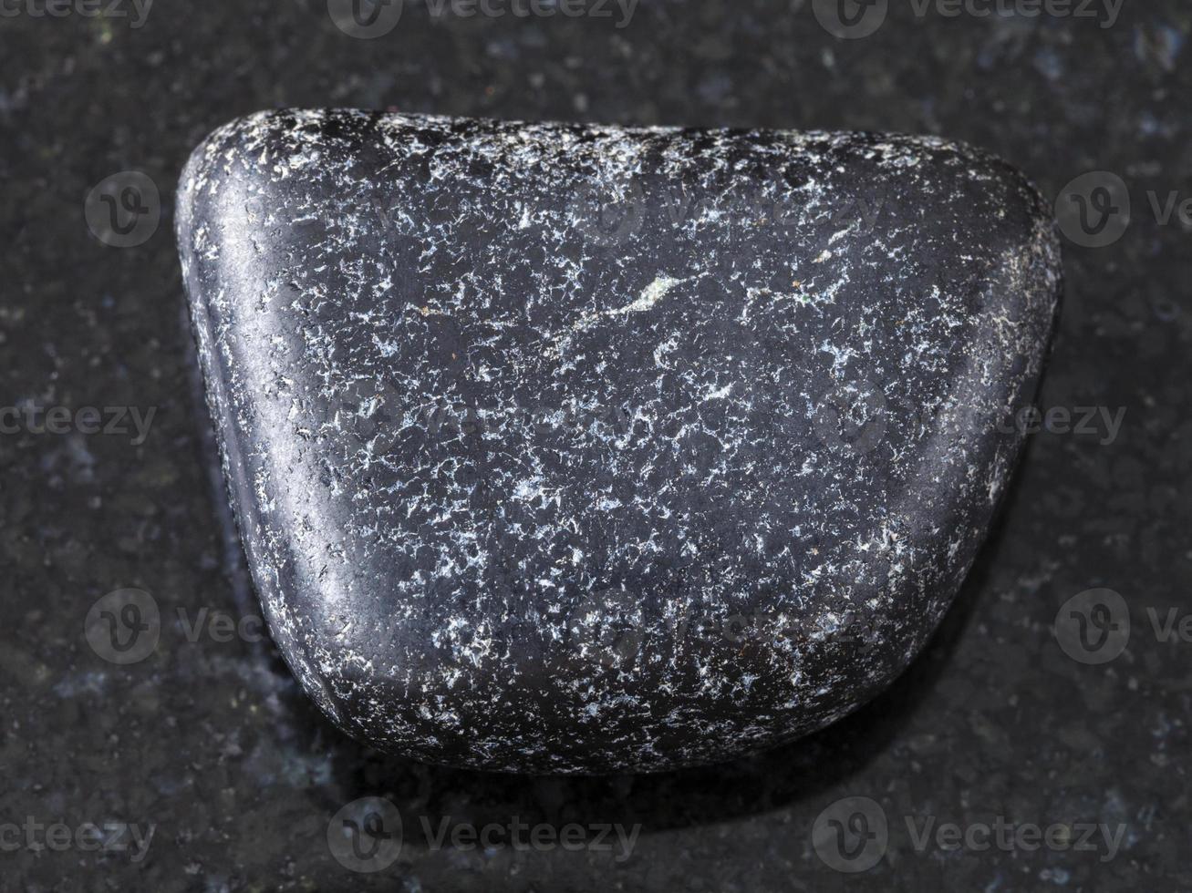 tumbled Chromite stone on dark background photo