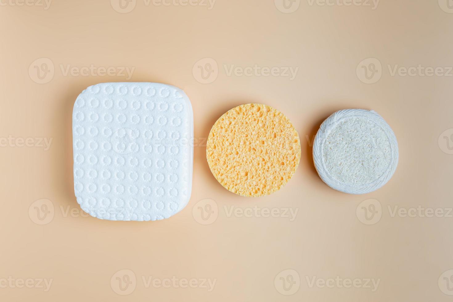 set of different sponges for the face. Cleansing and exfiliating sponges on beige background. Skin care concept photo