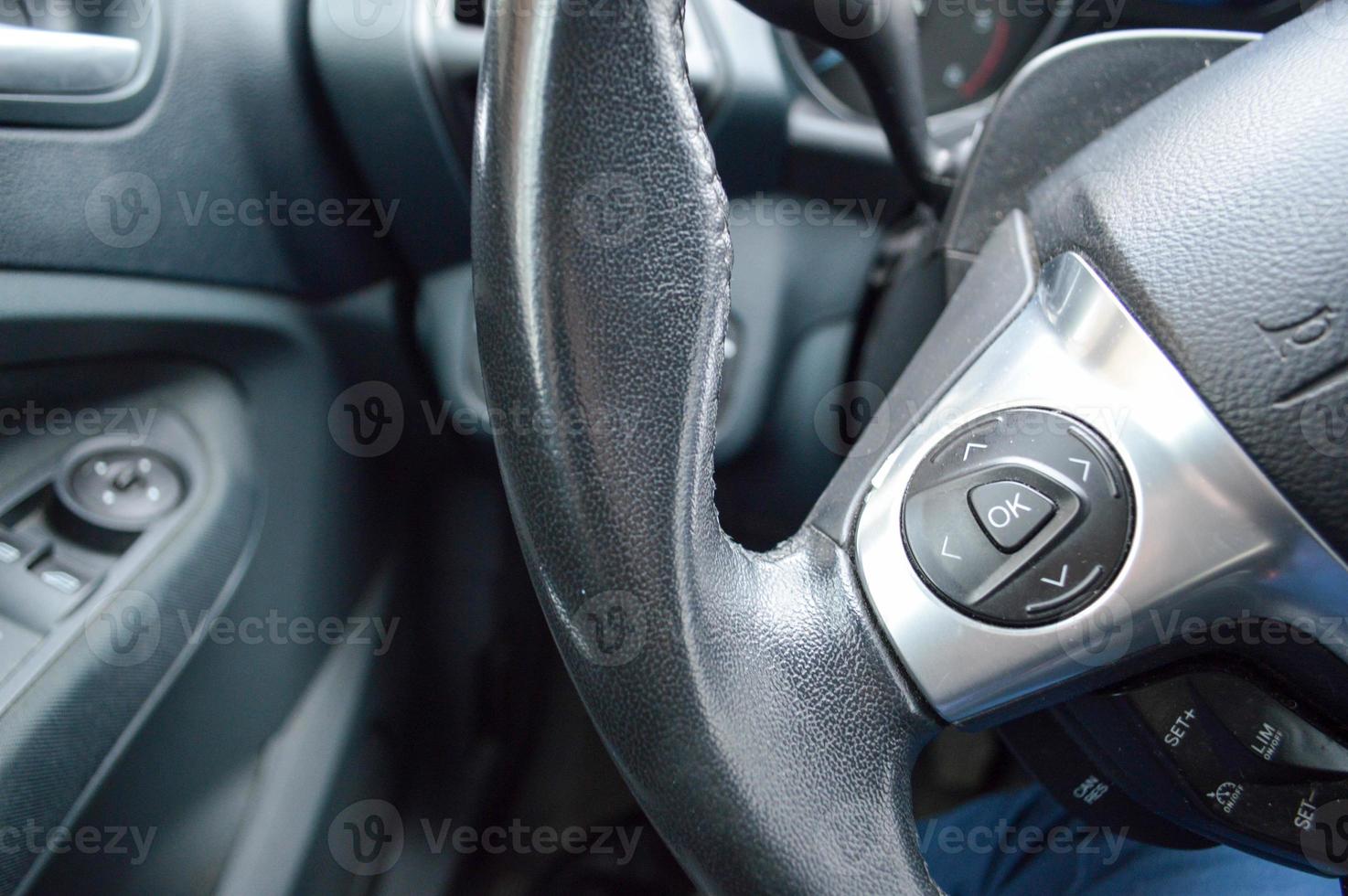 Buttons ok and arrows on the leather steering wheel of the car. photo