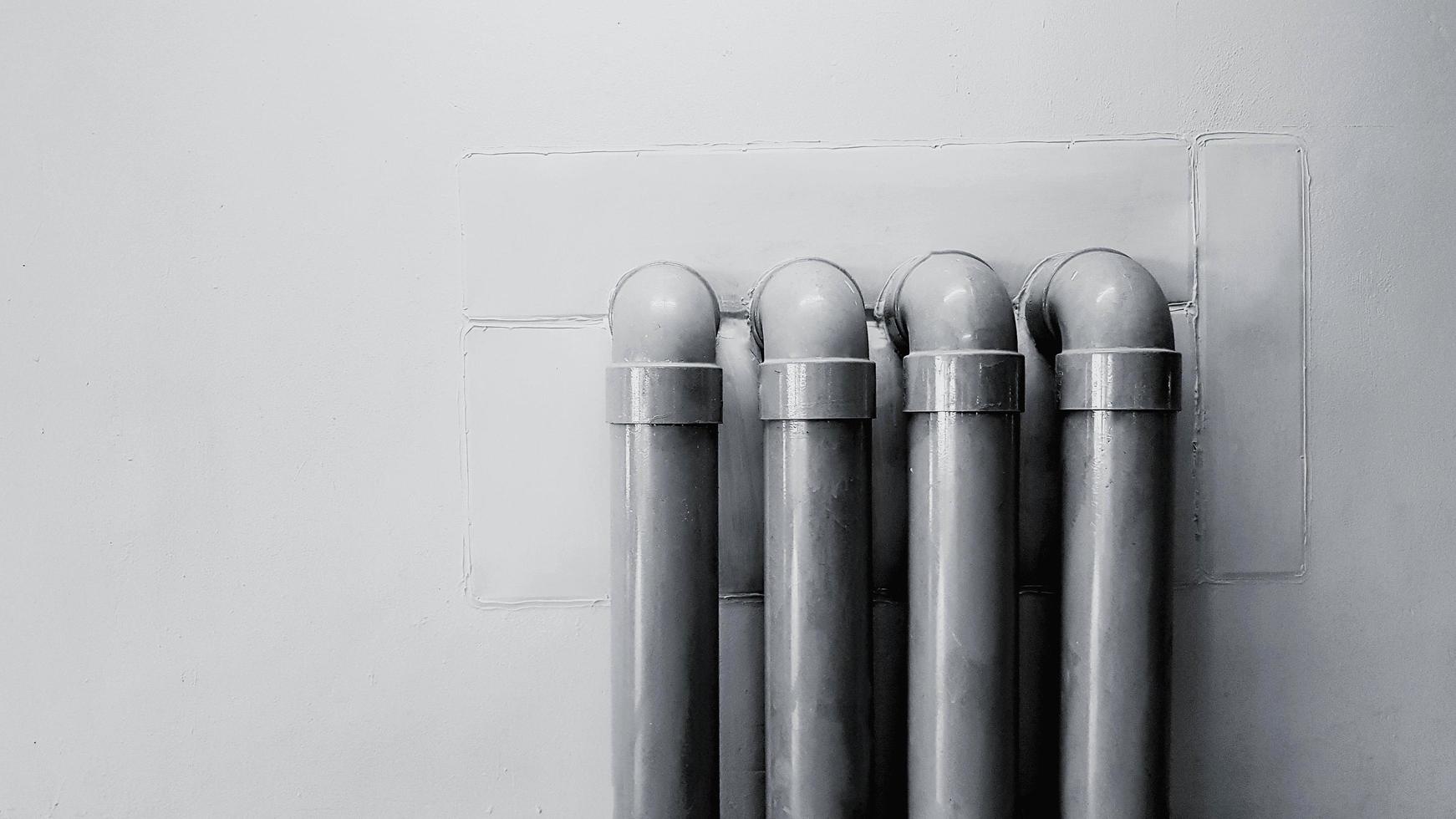 Four water pipeline on concrete wall for background with copy space in black and white tone. Oil pipe installed on floor in monochrome style. photo