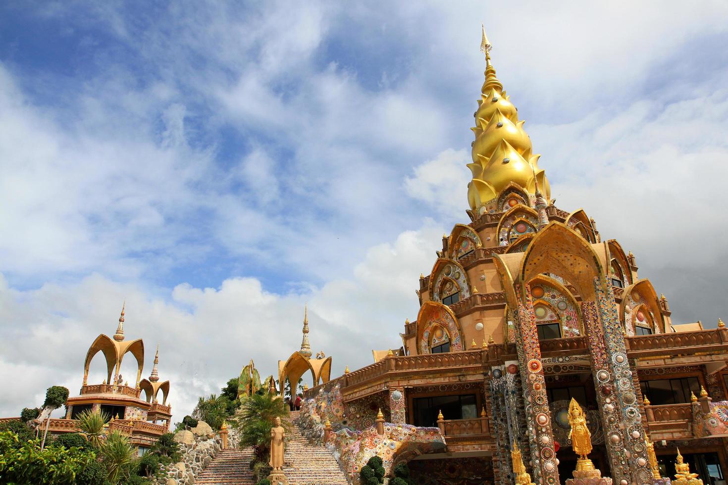 Golden pagoda of Wat Phra That Pha Son Kaew temple with blue sky and white clouds background and copy space. Landmark North of Thailand and Exterior design ancient building. Stairway to entrance. photo