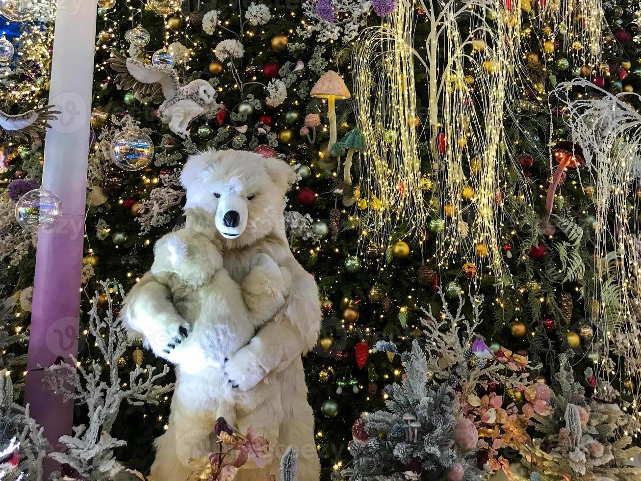 christmas decorations. a toy polar bear stands next to an artificial Christmas tree. mother bear holds her cub in her arms. Christmas Eve. stylized exhibition for visitors handmade photo