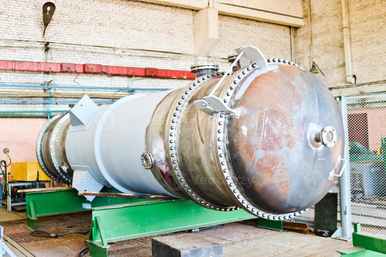 Large metal iron distillation column for separation of substances into fractions in the industrial premises of the shop at an oil refinery, chemical, petrochemical plant photo