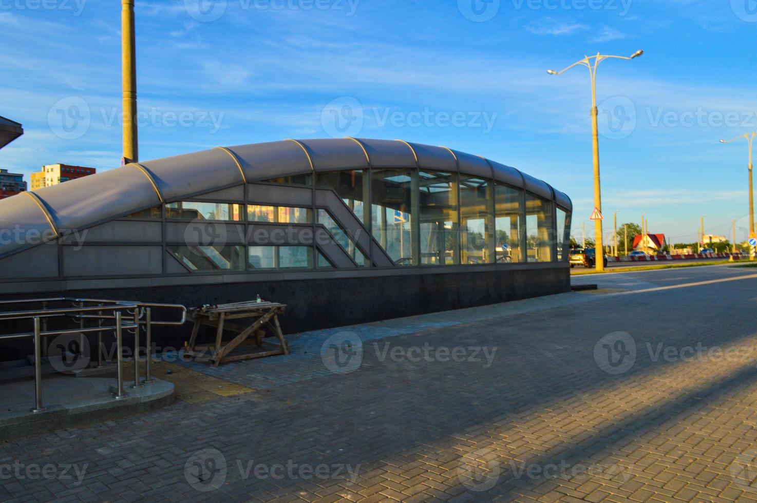 glass underpass for pedestrians. a large visor for descending into the ground, passage to the subway or crossing to another street. nearby lanterns and scaffolding photo