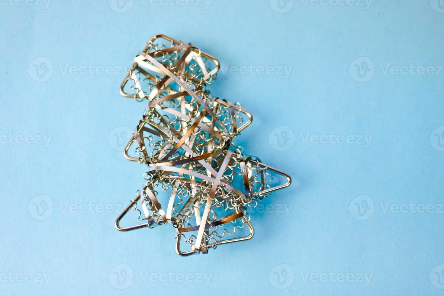 Festive New Year Christmas happy blue joyful background with a small toy metal iron golden homemade Christmas tree. Flat lay. Top view. Holiday decorations photo