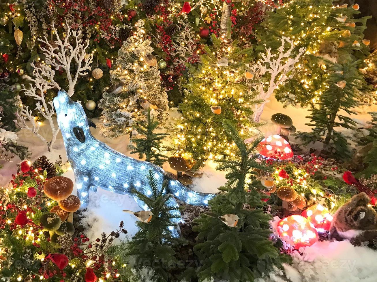 christmas decoration. cute decor for showcase. deer made of luminous garlands. bright, beautiful handmade deer. next to artificial Christmas trees decorated with balls photo