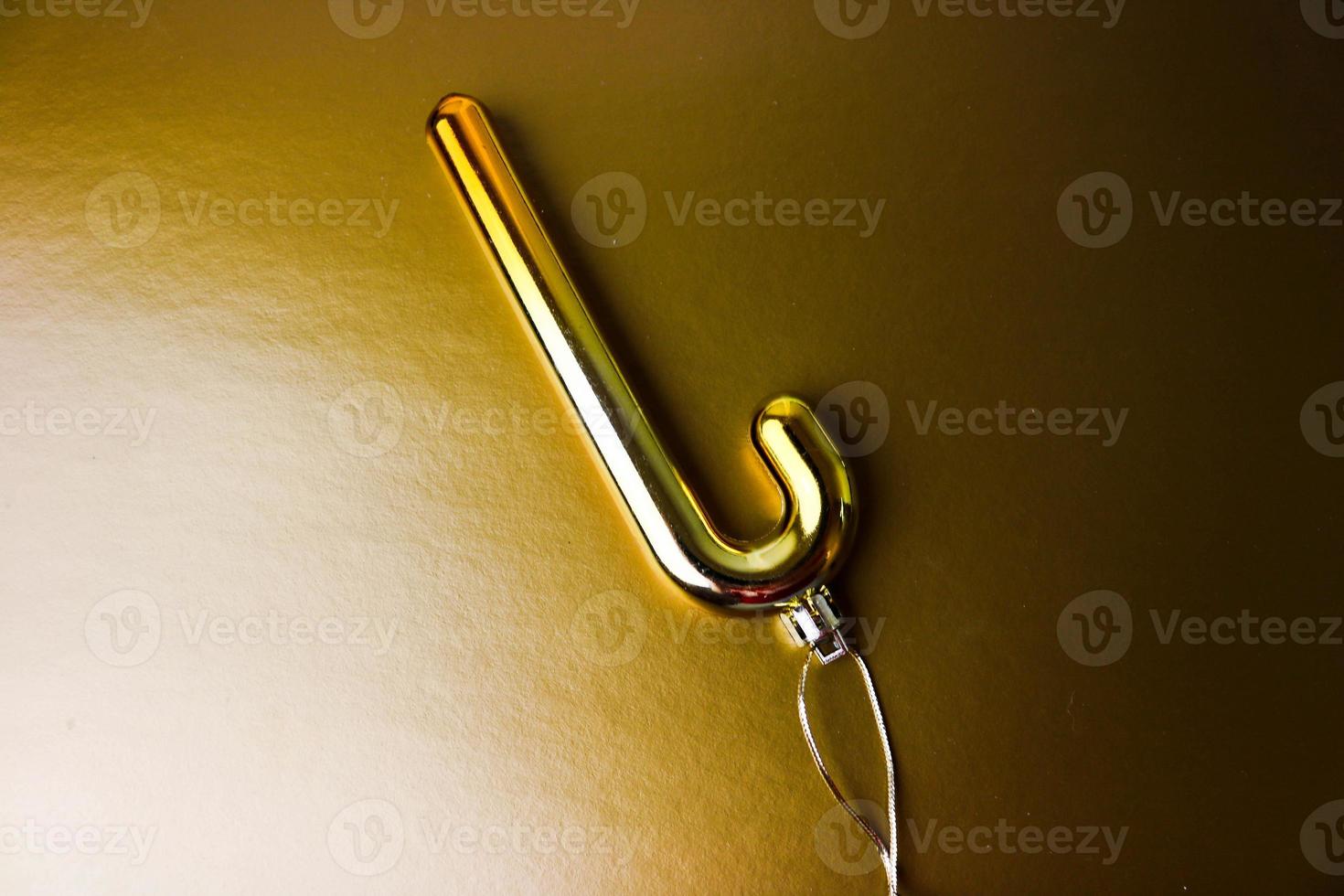 Colorful golden yellow plastic winter shiny Christmas decorative beautiful xmas festive Christmas tree candy cane toy on a yellow gold background photo