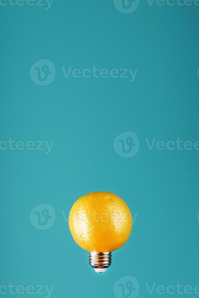 Lemon as a light bulb in levitation on a blue background. The conceptual idea photo