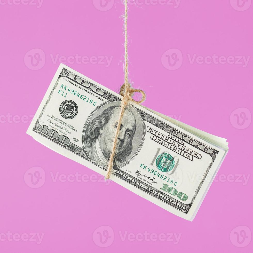 Money tied dollars on a rope, on a blue background. Isolate, free up space. photo