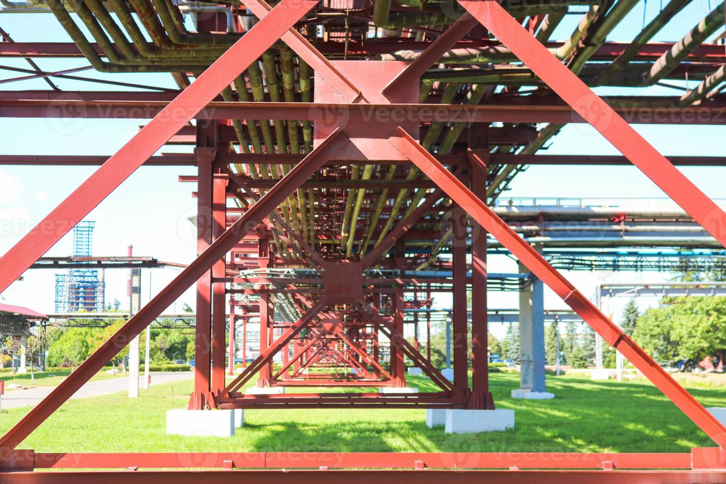 estructuras de metal rojo, soportes de ruedas para tuberías, caballete de tuberías de grandes vigas, pilotes y refuerzos en la refinería de petróleo, petroquímica, planta industrial química, la empresa foto
