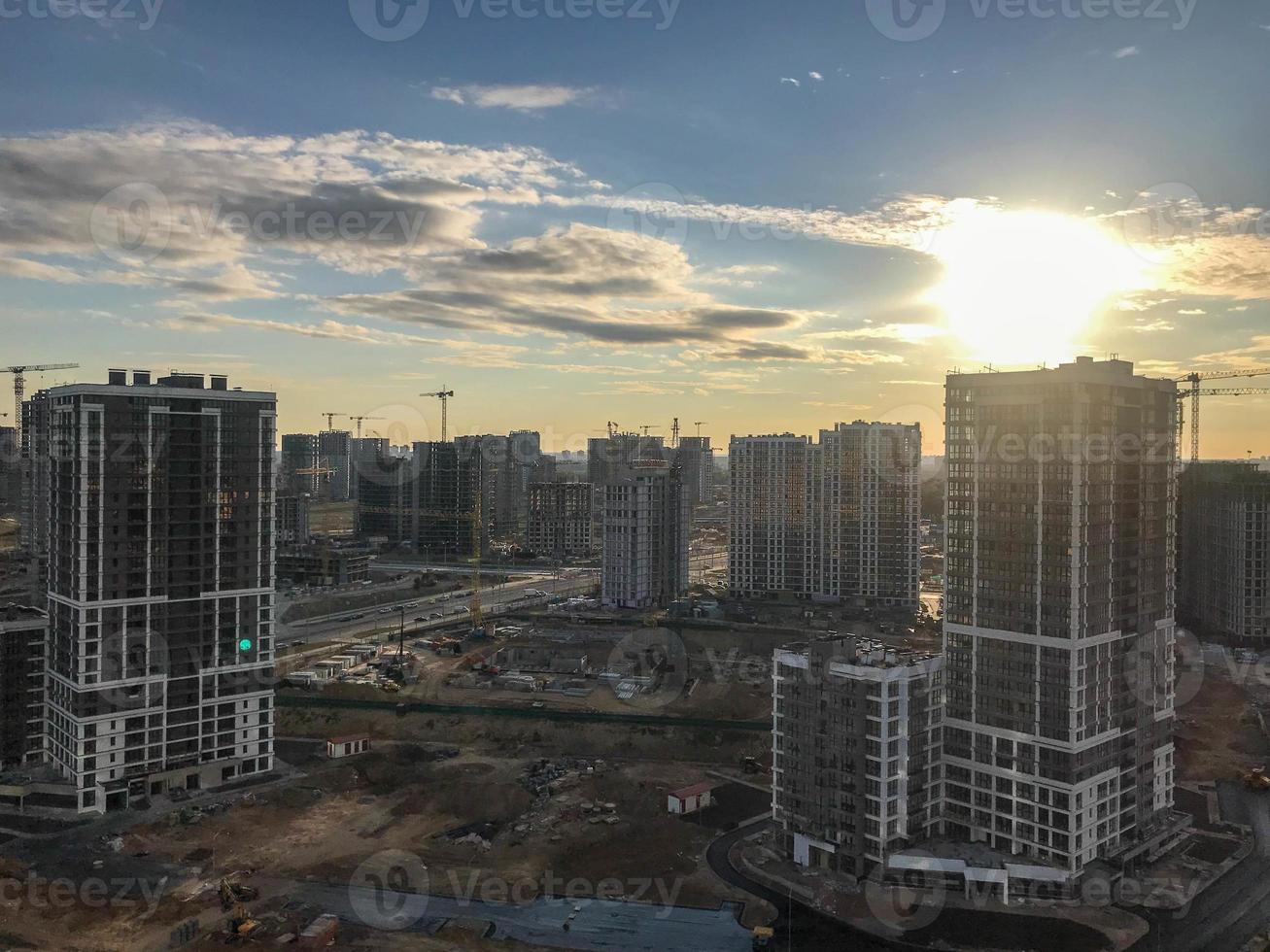 a new neighborhood in the city. shooting from a height. urban urban landscape. tall glass multi-storey buildings of different colors and different heights. against the background of the sun photo