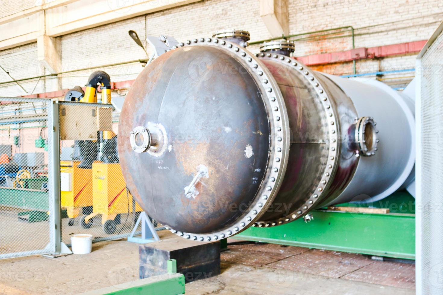 Large metal iron distillation column for separation of substances into fractions in the industrial premises of the shop at an oil refinery, chemical, petrochemical plant photo