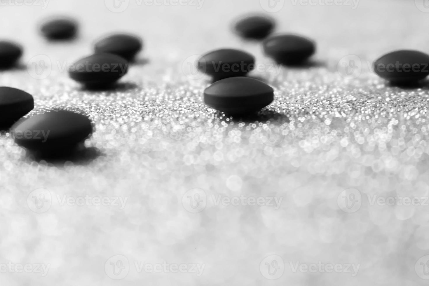 Little beautiful medical pharmaceptic round pills, vitamins, drugs, antibiotics on a black and white background, texture. Concept medicine, health care. Flat lay, top view photo