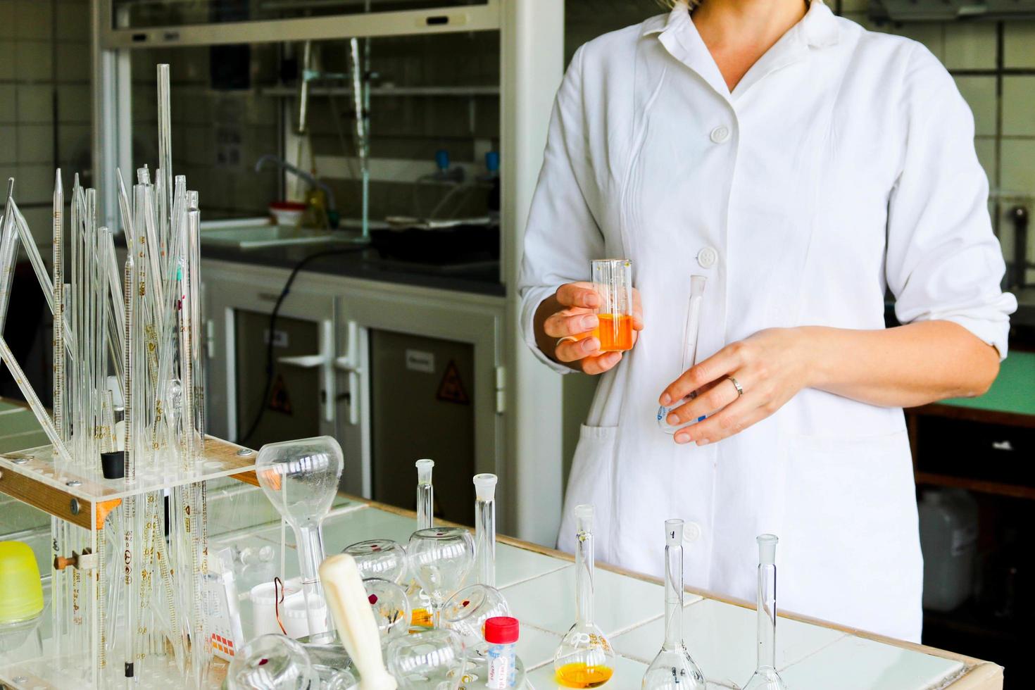 una asistente de laboratorio, doctora, química, trabaja con matraces, tubos de ensayo, hace soluciones, medicinas, mezcla los ingredientes en el laboratorio. asistente de laboratorio lleva a cabo la investigación foto