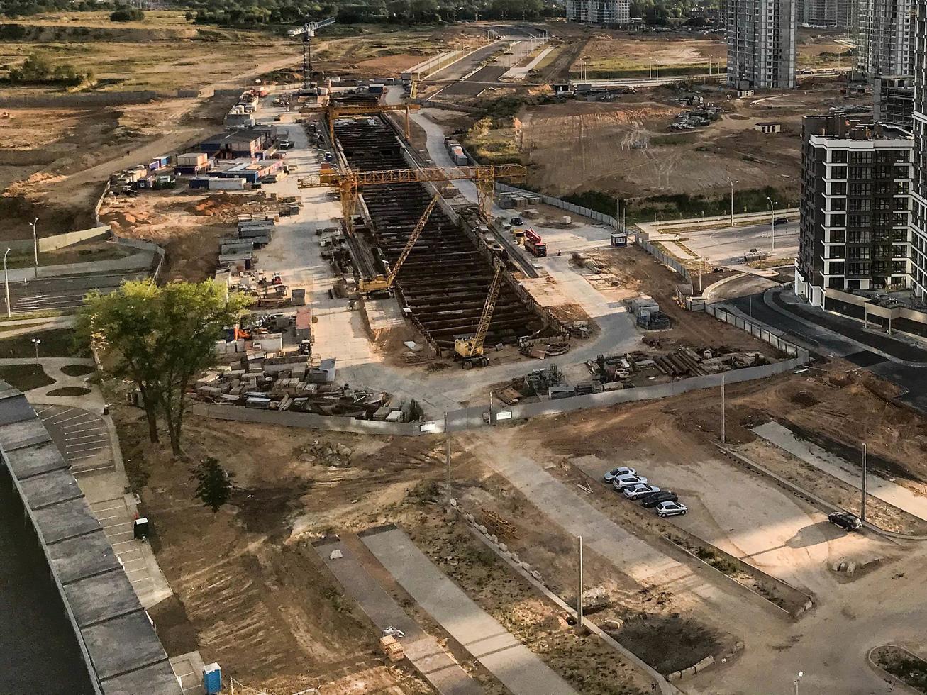 construcción de una nueva estación de metro. excavación de un túnel subterráneo con una gran grúa pórtico. Disparos desde altura, fotografía aérea. Las excavaciones están en marcha en el nuevo barrio. foto