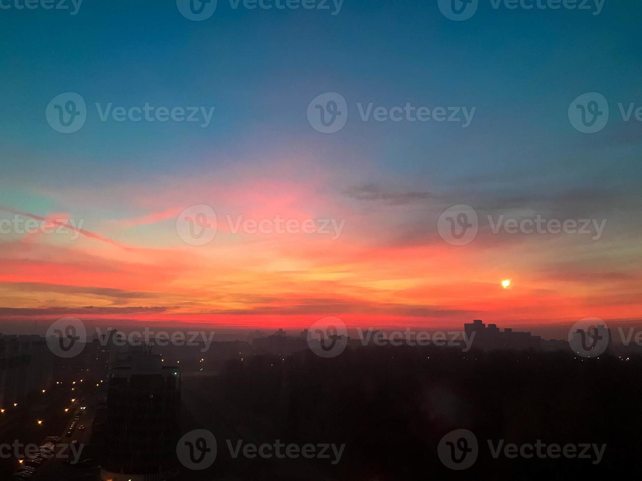 Beautiful red dawn of the sun in a big city metropolis with buildings and clouds. The view from the height photo