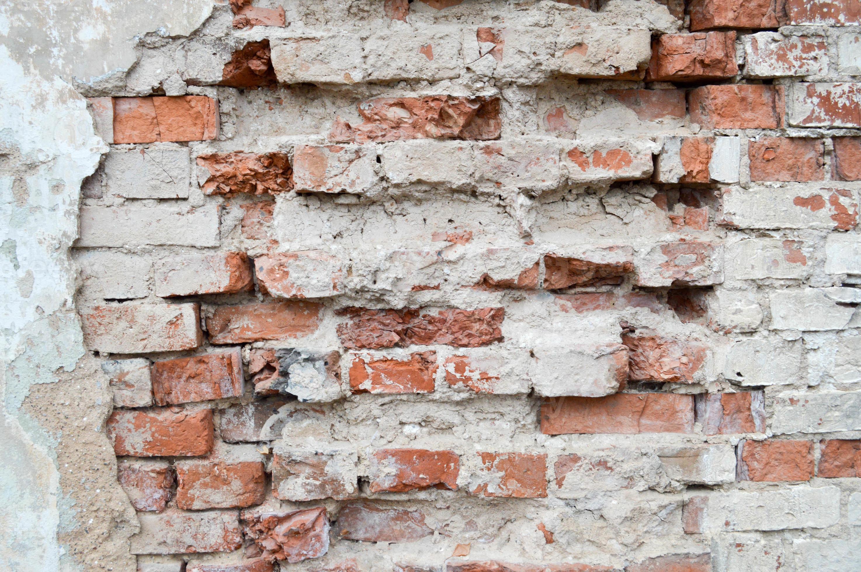 Texture of the plaster of the brick wall with old, broken, cracked red