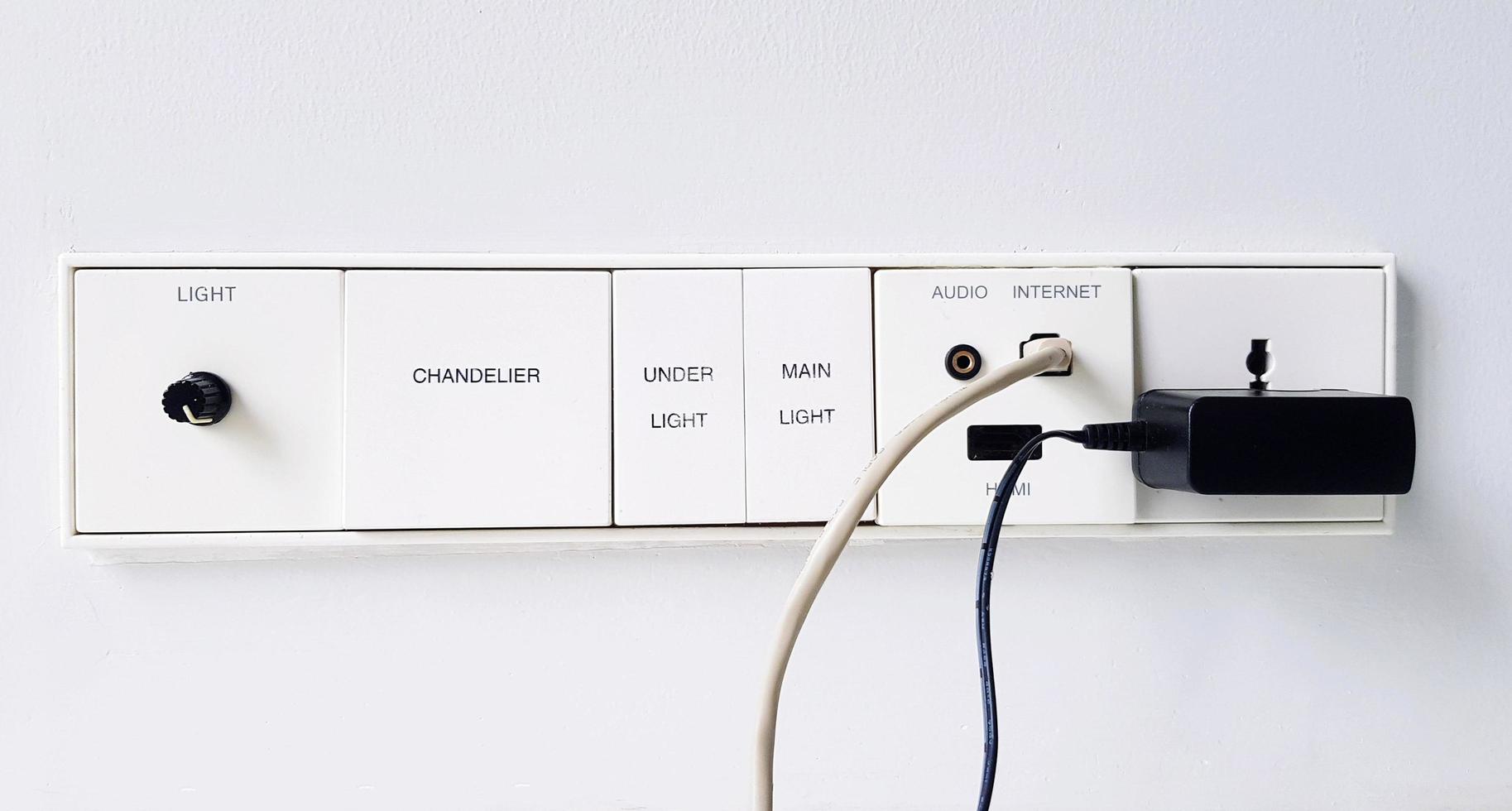 Group of switch panel with light switch, internet connection, audio, HDMI and AC outlet plug installed on white wall with copy space. Control device and Technology concept. photo