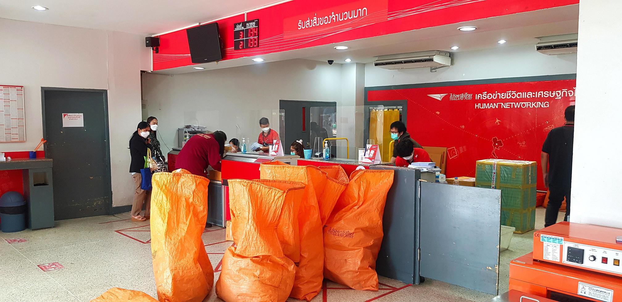 chonburi, tailandia - 19 de abril de 2022 muchas personas sentadas en un sofá y tomando fotos con fondo de cielo azul en un café o restaurante decorado con un tono rosa como asiento y sombrilla en la playa.