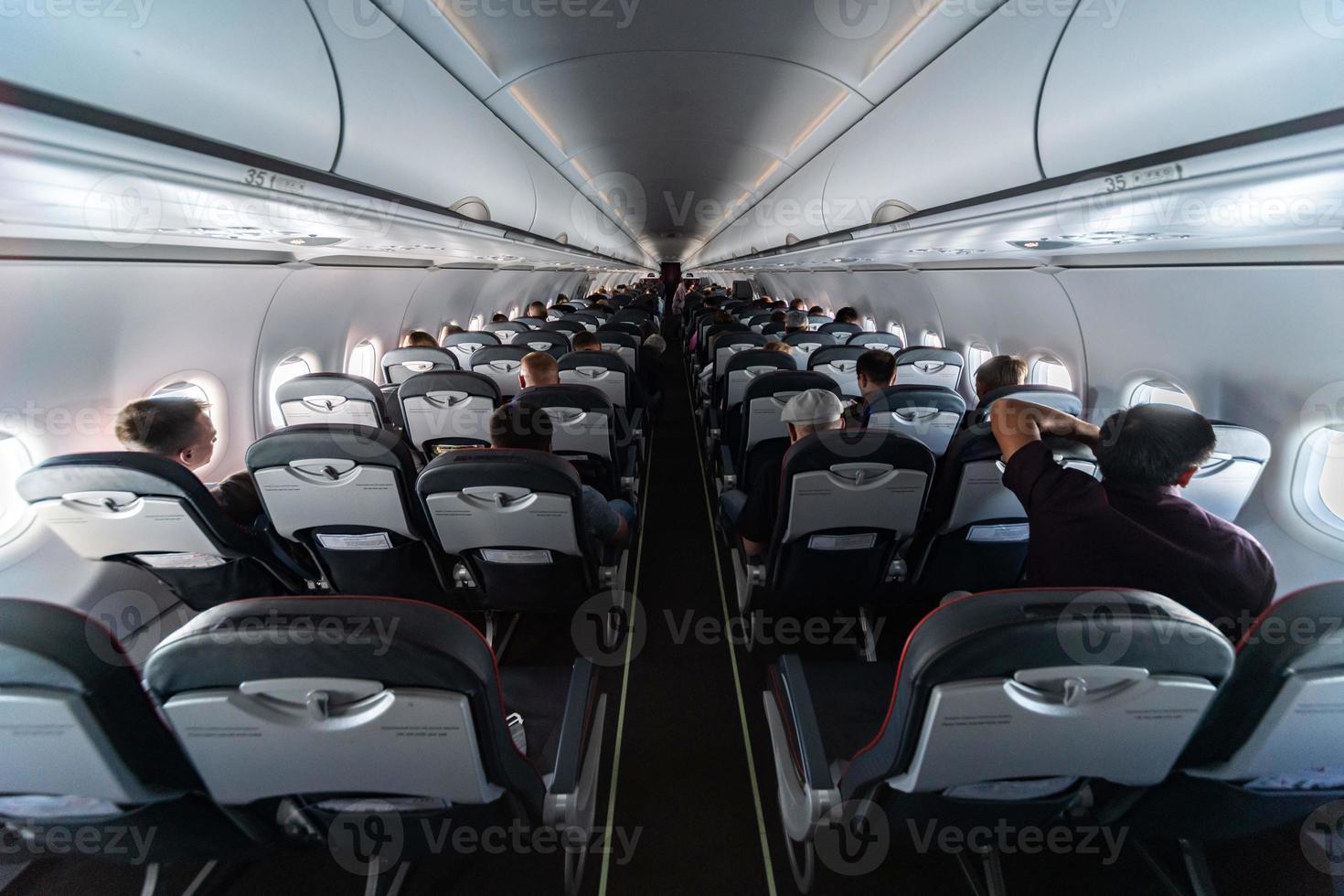 asientos de cabina de avión con pasajeros. clase económica de las nuevas aerolíneas de bajo coste más baratas sin retrasos ni cancelaciones de vuelo. viaje viaje a otro país. foto