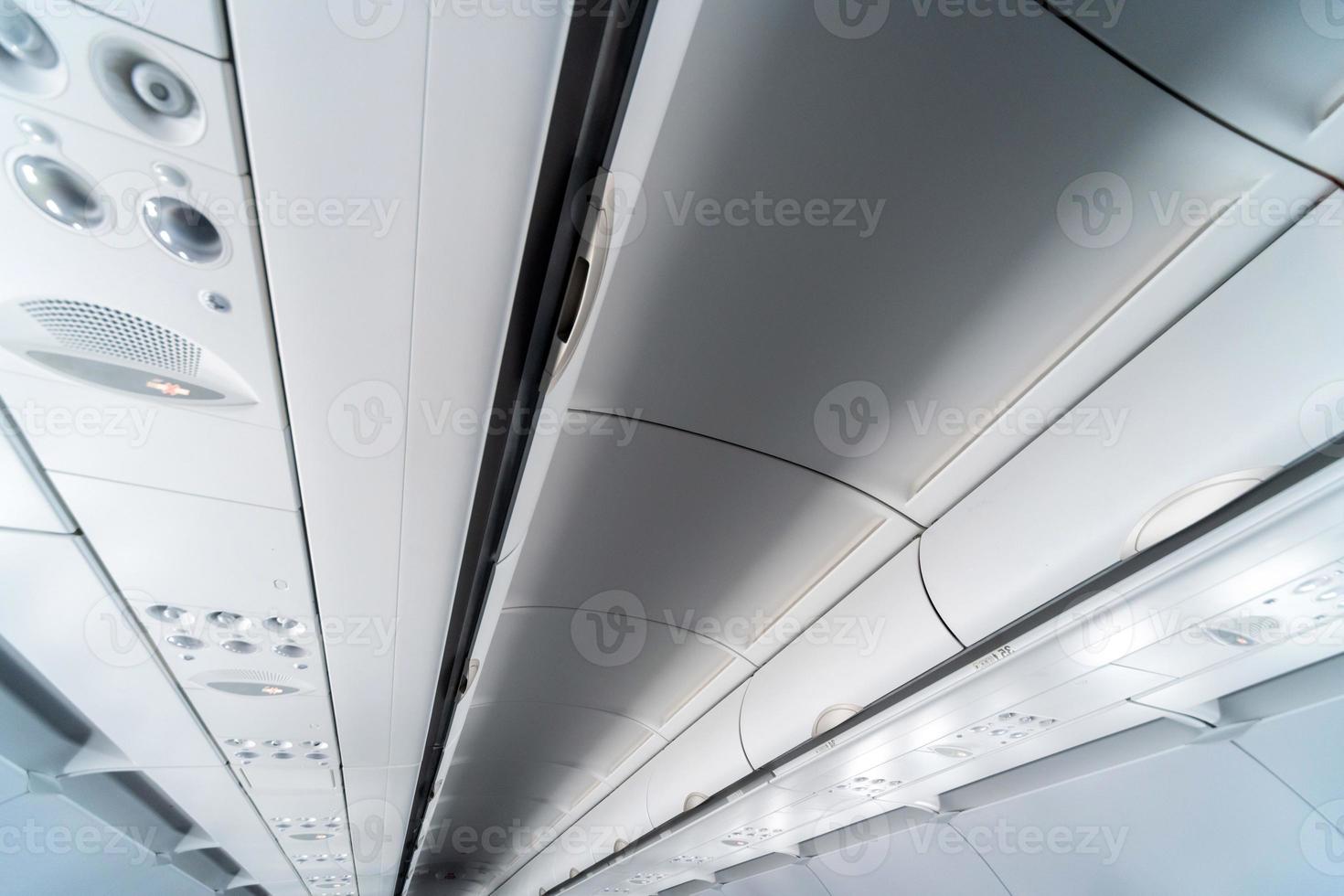 Airplane air conditioning control panel over seats. Stuffy air in aircraft cabin with people. New low-cost airline photo