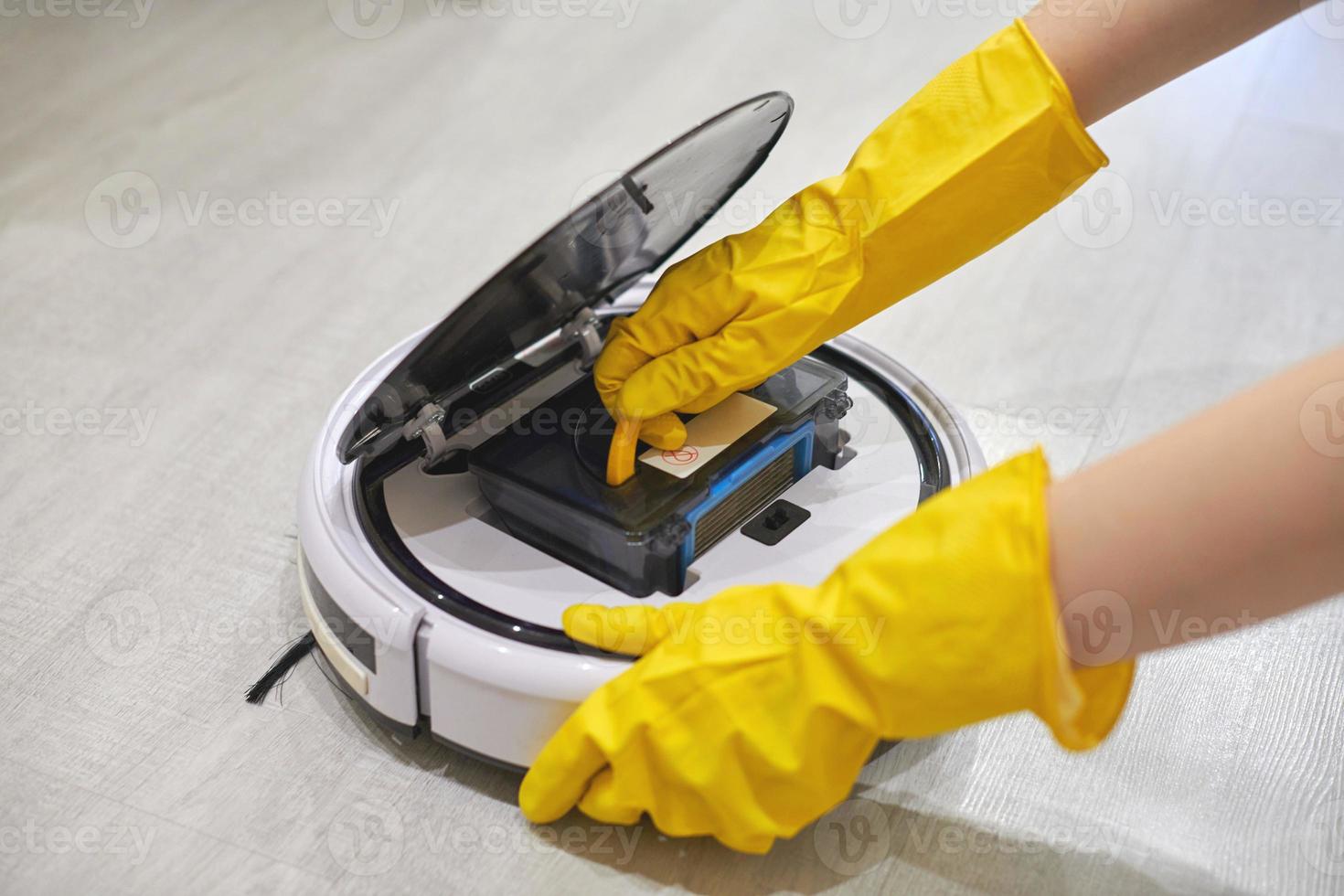 Robot vacuum cleaner, inserting filter, cleaning. Close up. photo