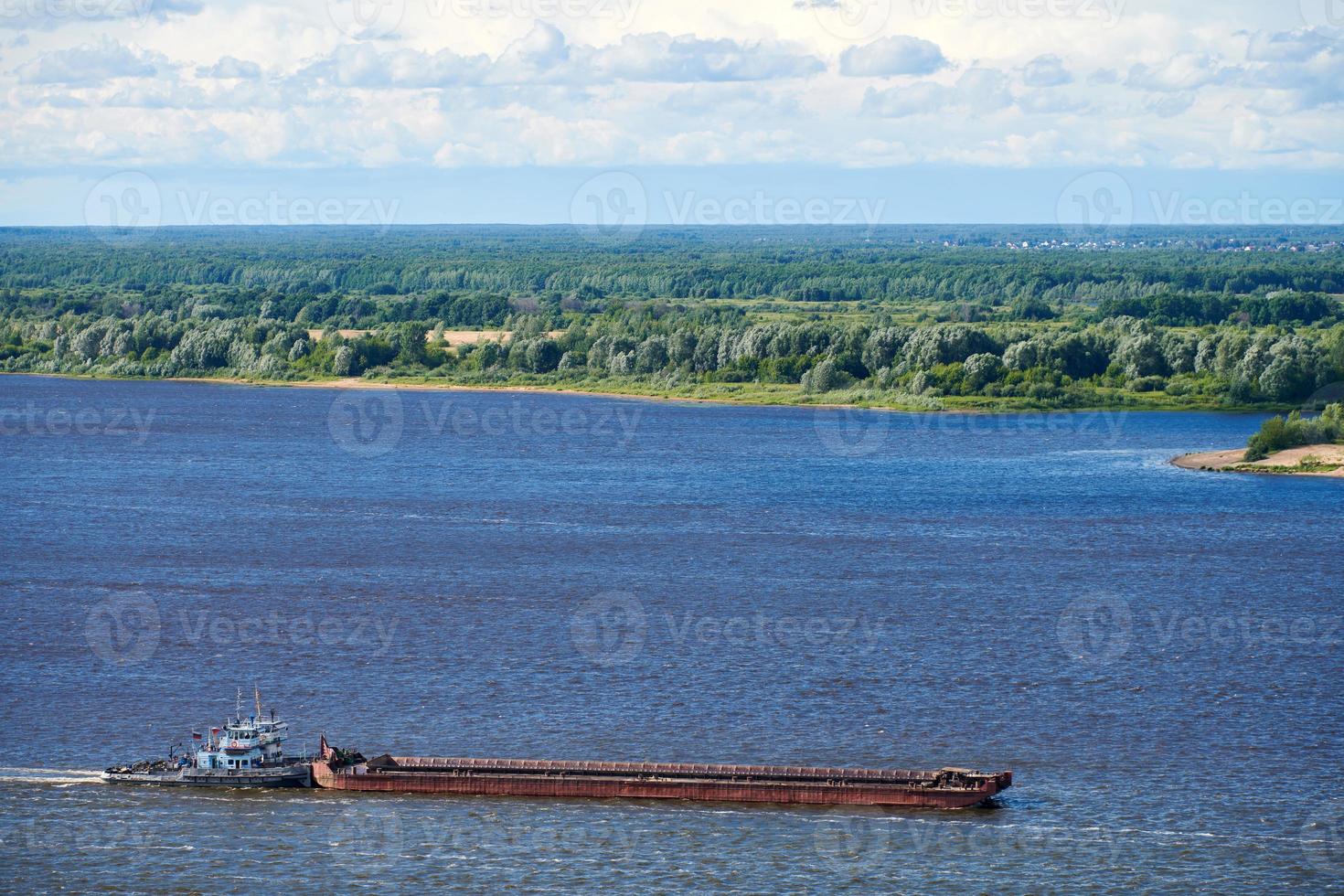 Barge on river sailing to port for cargo. Transport for transportation of crushed stone and sand photo