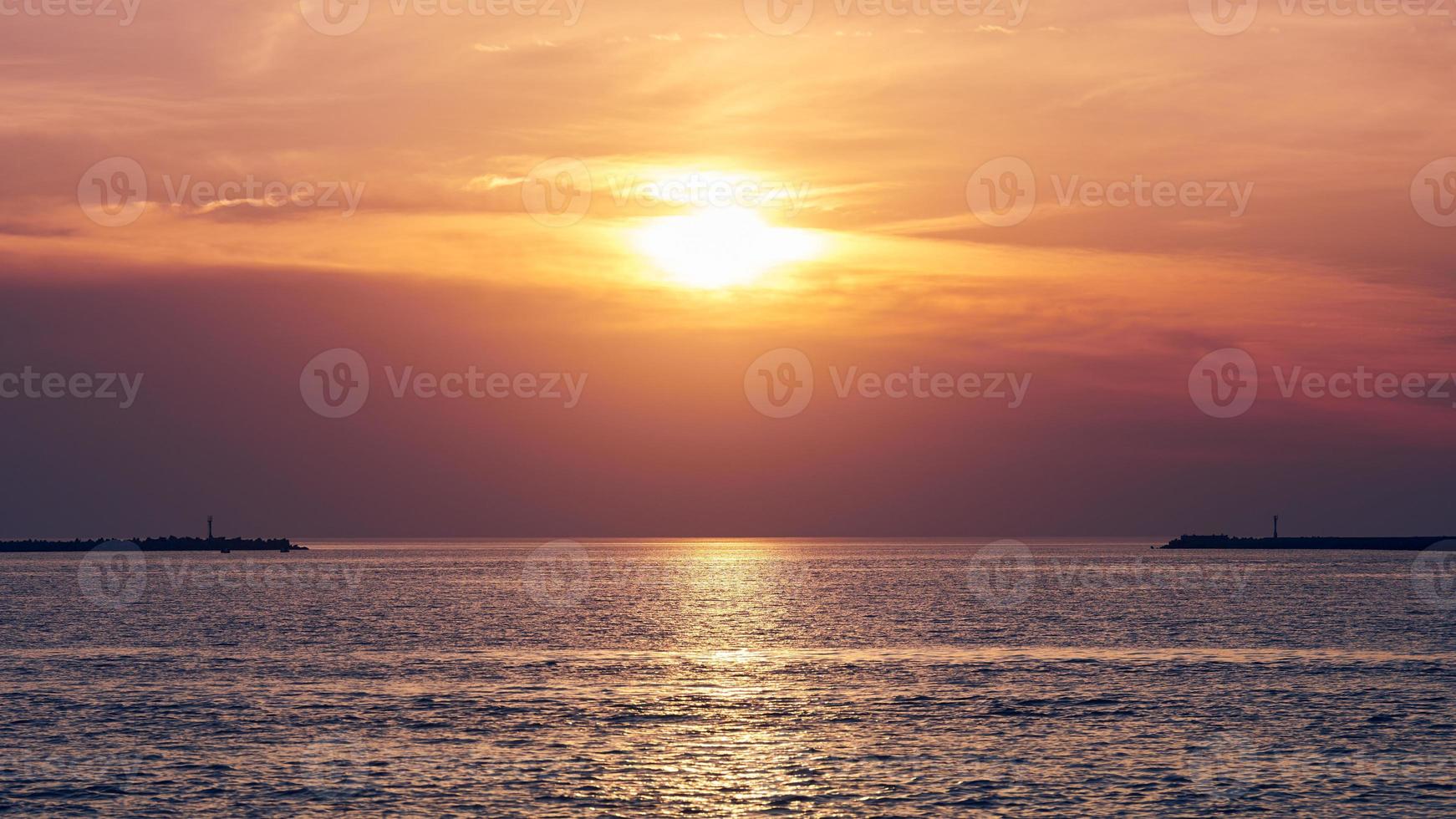 Calm sea with sunset sky, beautiful panoramic view, amazing dramatic rising sun reflected in water photo