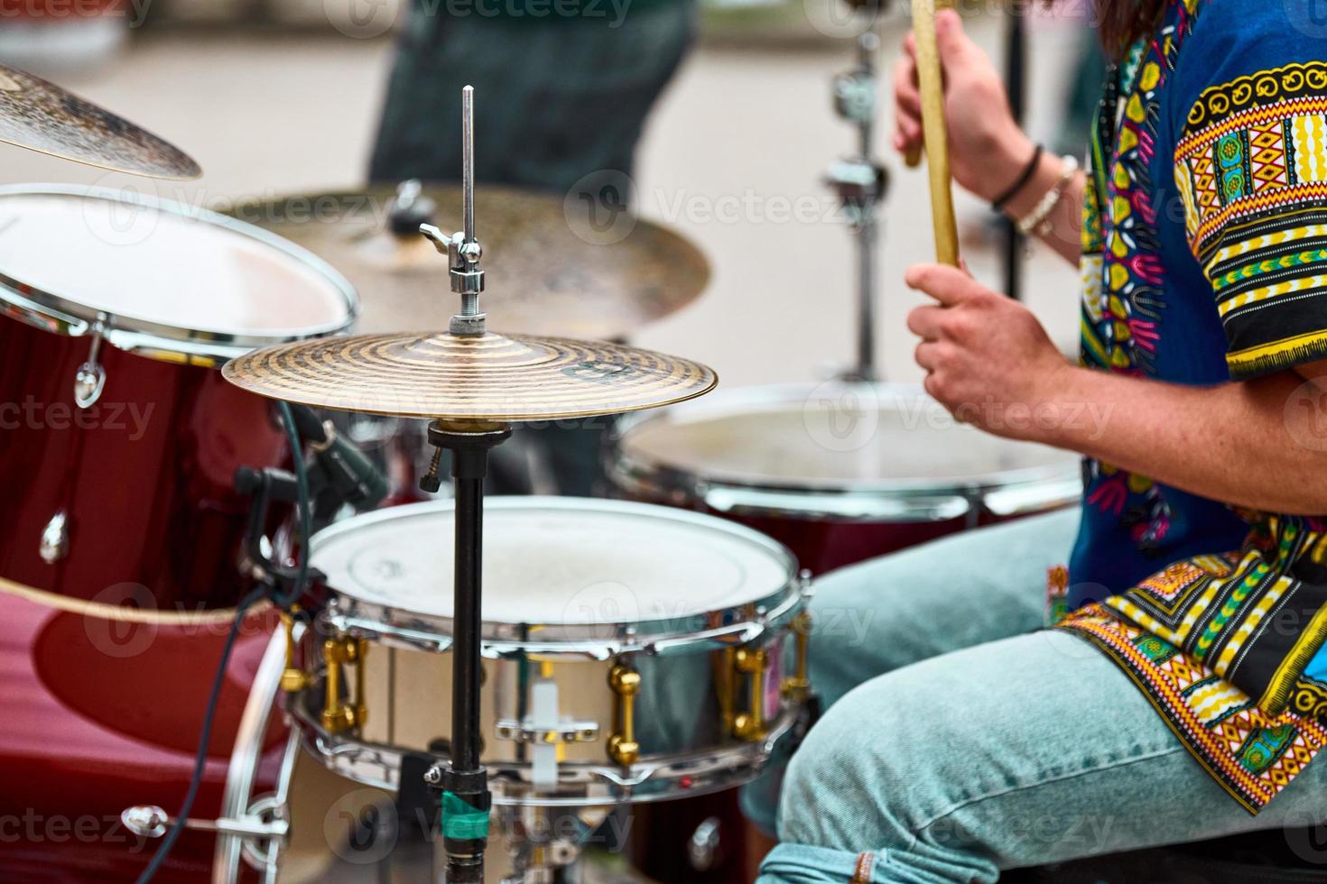 Drummer man playing drums percussion with sticks, drum kit on concert stage, drumsticks and drums photo
