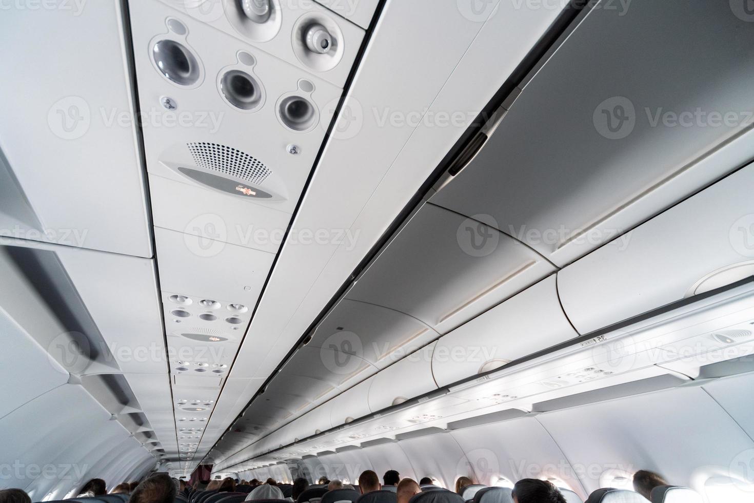 Airplane air conditioning control panel over seats. Stuffy air in aircraft cabin with people. New low-cost airline photo