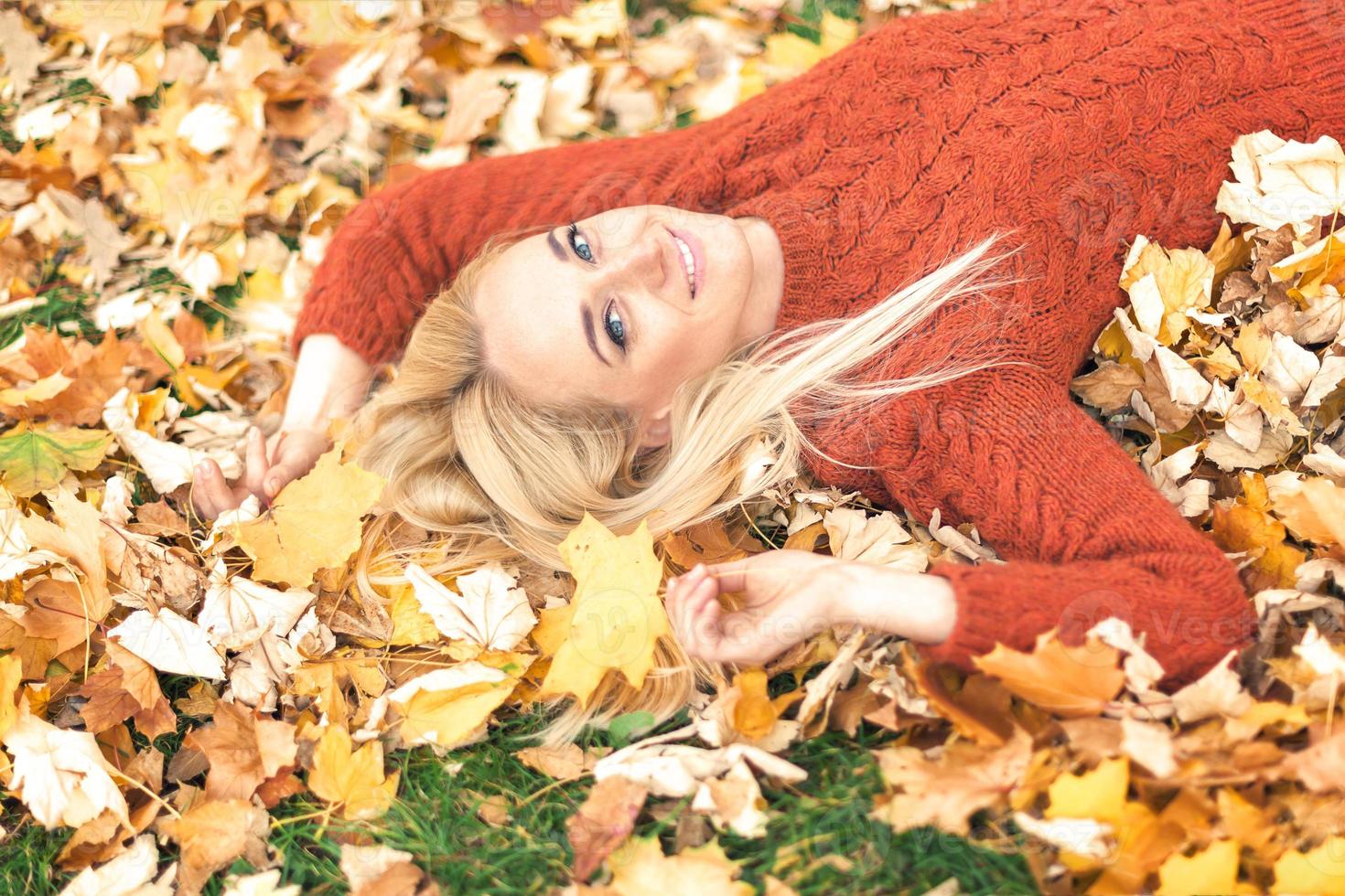Woman lying down on yellow leaves photo