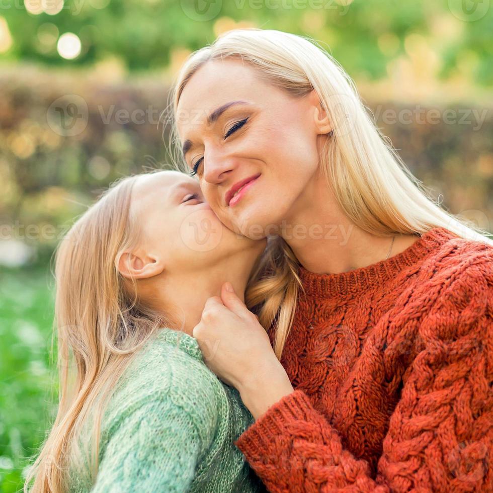 Daughter kisses her young mother photo