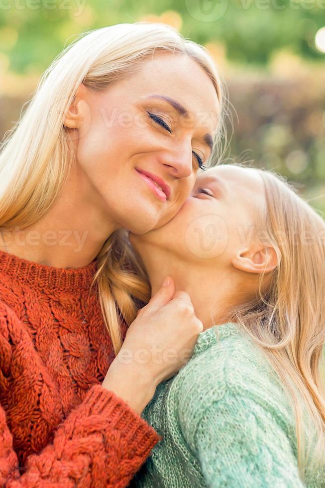 Daughter kisses her young mother photo