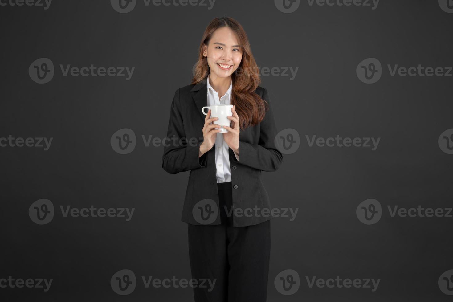 mujer de negocios de pie con una taza de café con leche en camisa blanca foto