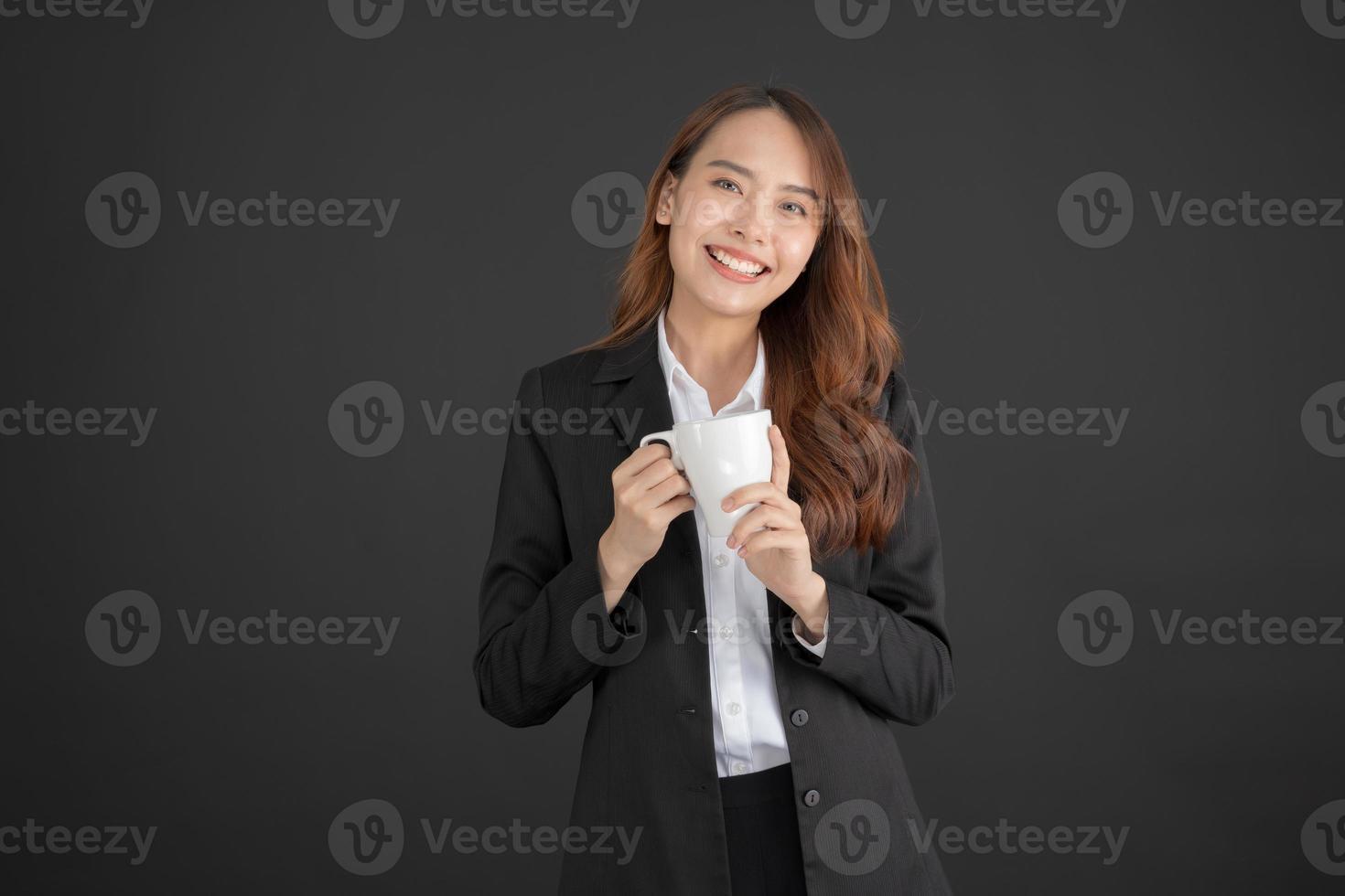 mujer de negocios de pie con una taza de café con leche en camisa blanca foto