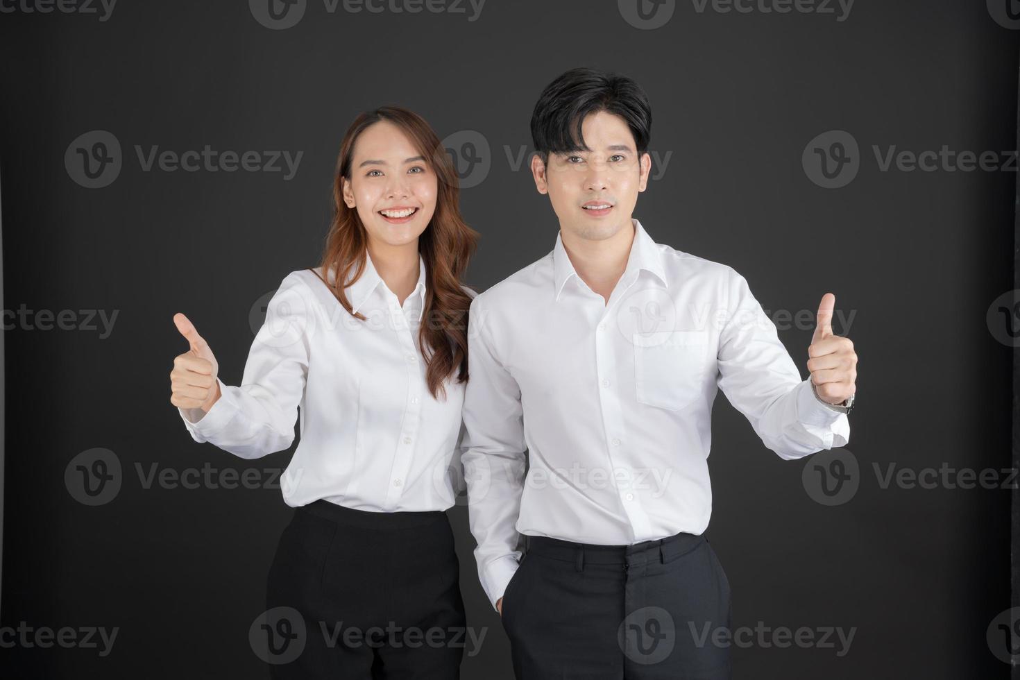 Two young businessmen raising their thumbs forward. photo