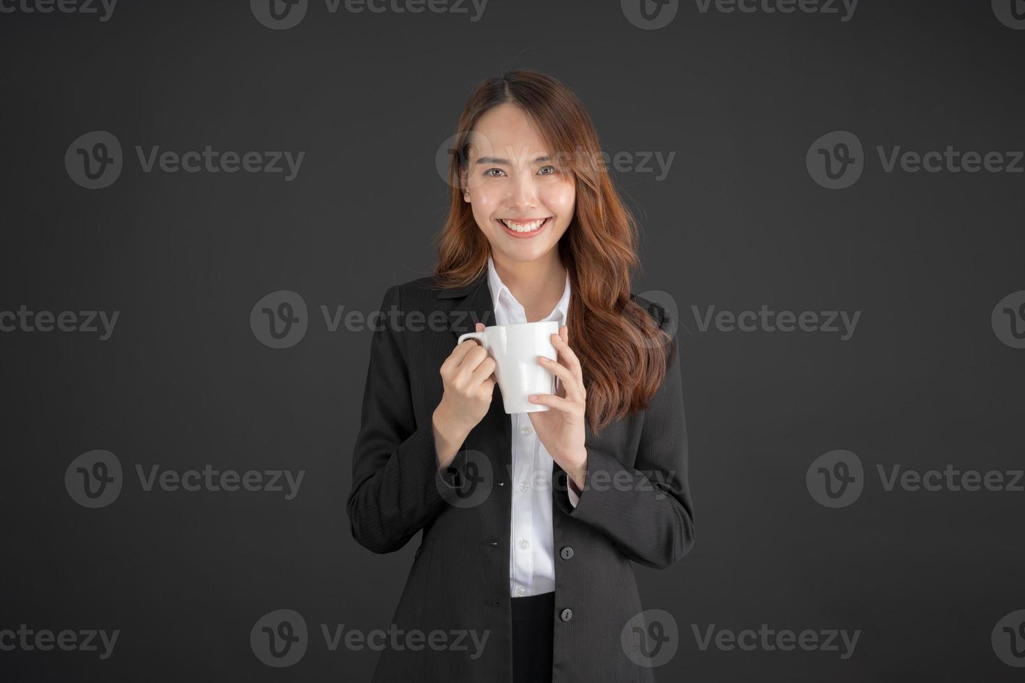 mujer de negocios de pie con una taza de café con leche en camisa blanca foto