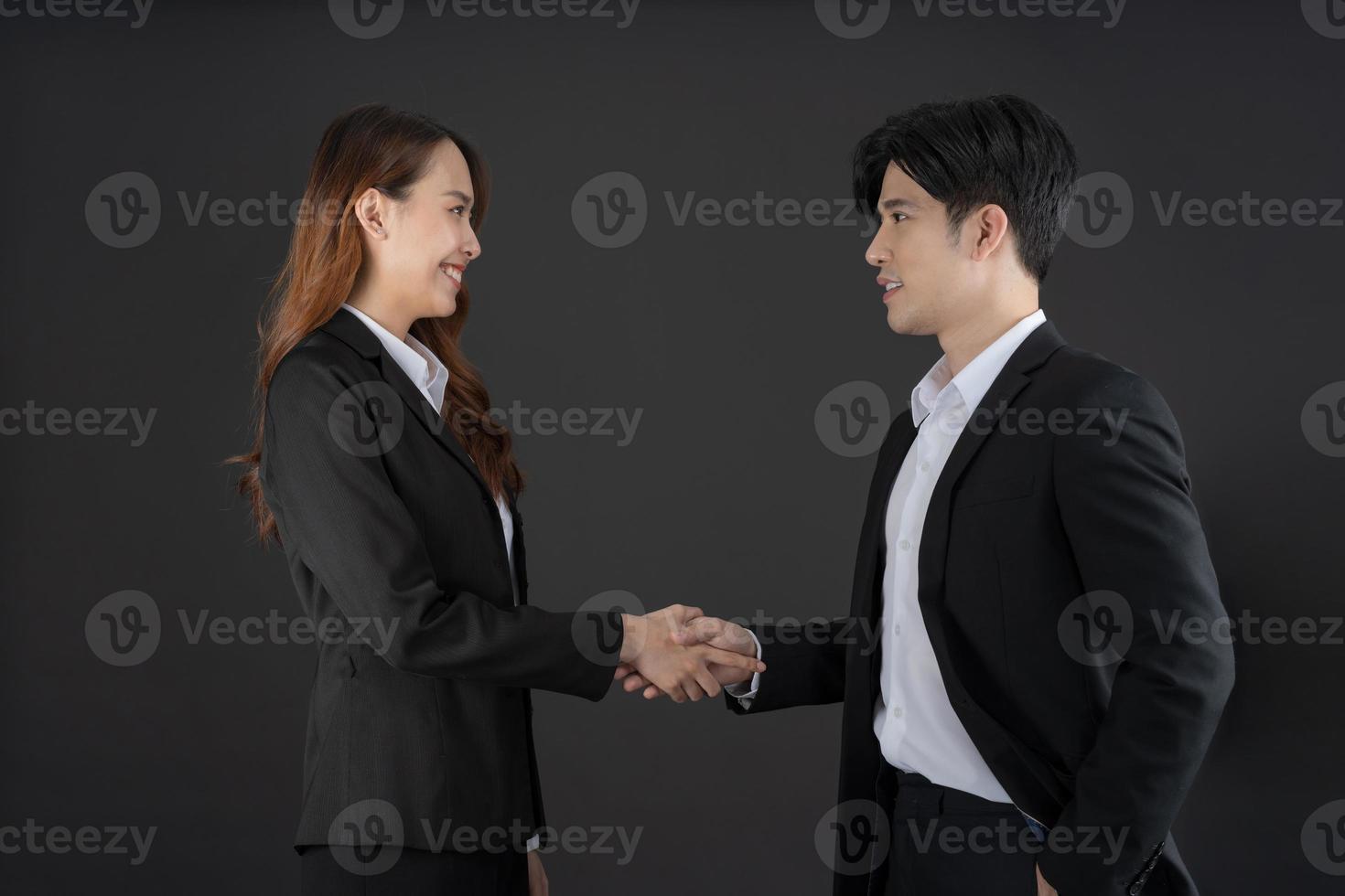 The two young businessmen shook hands to congratulate. photo