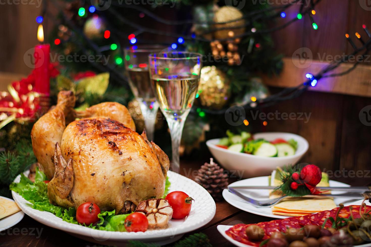 pavo o pollo al horno. la mesa navideña se sirve con un pavo, decorado con oropel brillante y velas. pollo frito, mesa. cena de Navidad. foto